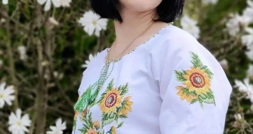 Women's white short-sleeved embroidered shirt with floral ornament